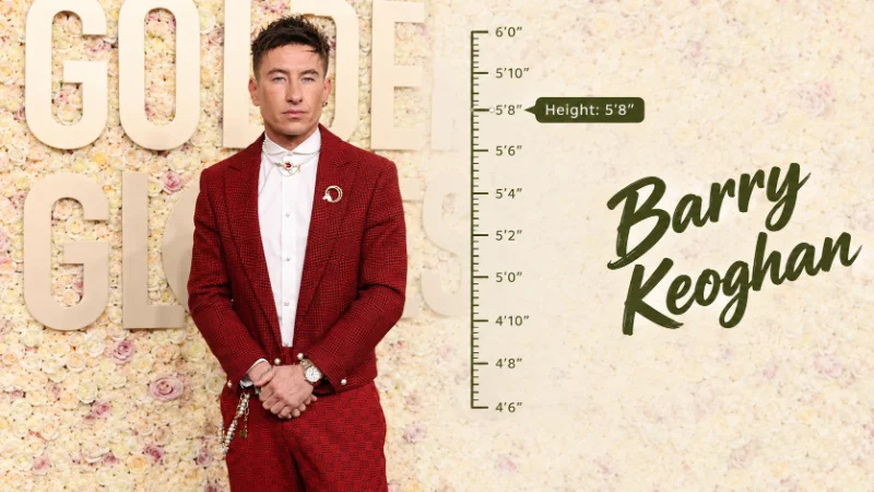 Barry Keoghan walking a premiere red carpet in a dark tailored overcoat