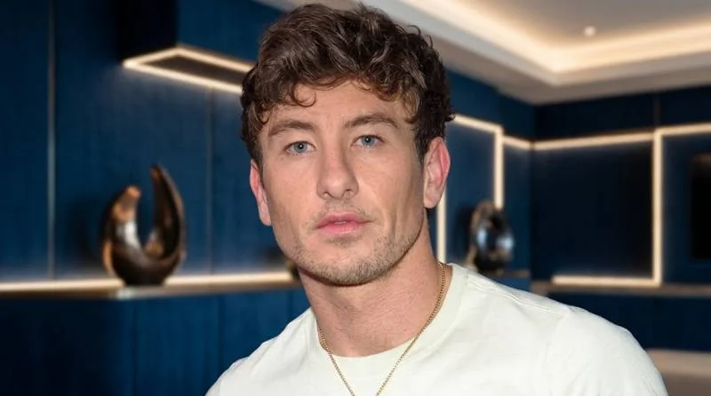 Barry Keoghan in period costume on a coastal film set between takes